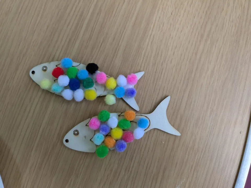 Colourful fish made with pom-poms during Cake and Craft.